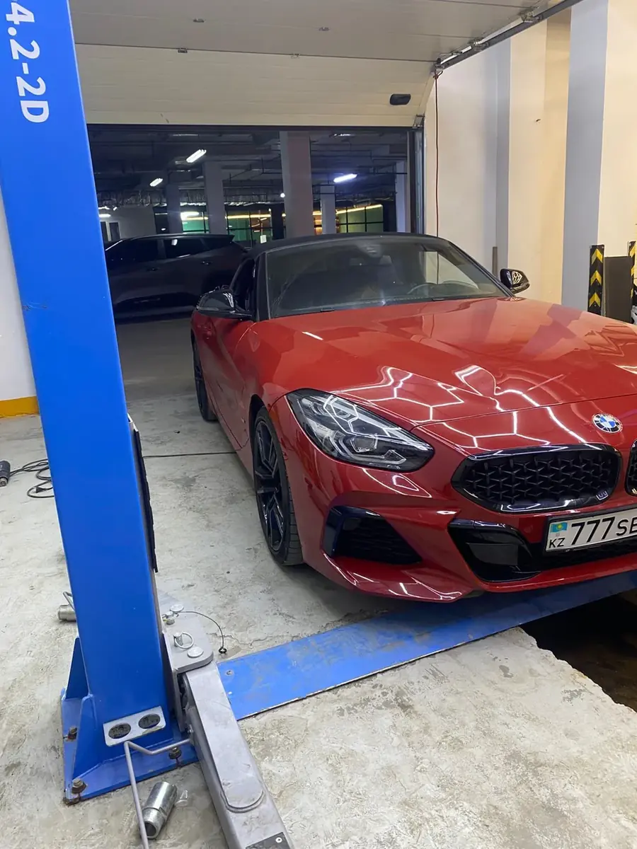 Красный BMW Z4 на подъёмнике - локальная покраска детали за 3 часа